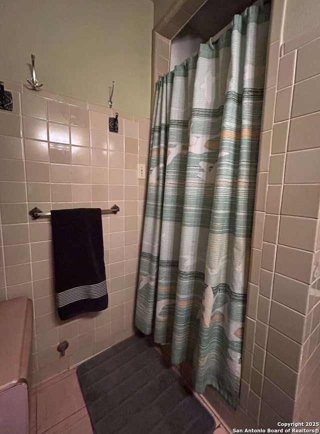 bathroom with tile walls and walk in shower