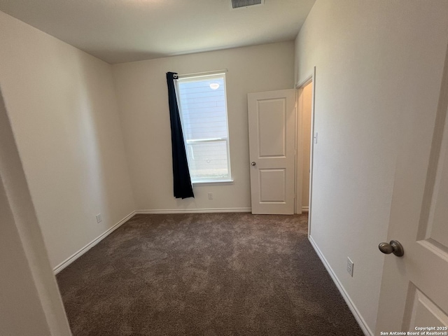 spare room with dark carpet