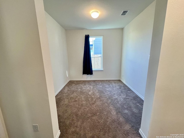 spare room with dark carpet