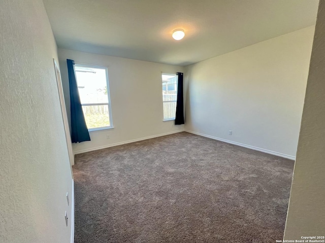 empty room with dark colored carpet