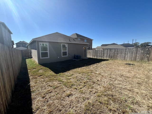 back of property featuring central AC and a lawn