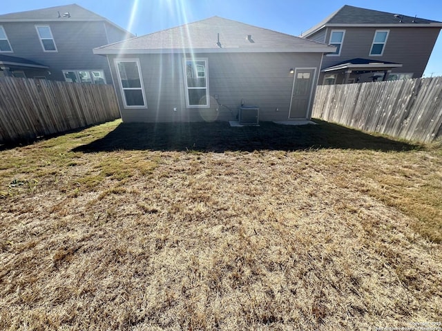 rear view of house with a lawn and cooling unit