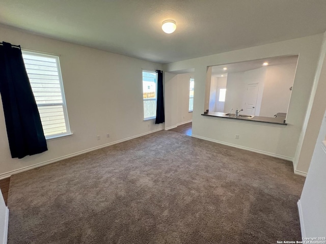 unfurnished room with sink and dark carpet