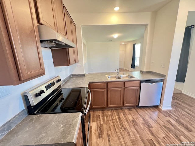 kitchen with stainless steel dishwasher, range with electric stovetop, light wood-type flooring, and sink