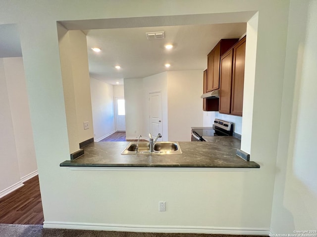 kitchen featuring kitchen peninsula, dark hardwood / wood-style floors, stainless steel range with electric cooktop, and sink