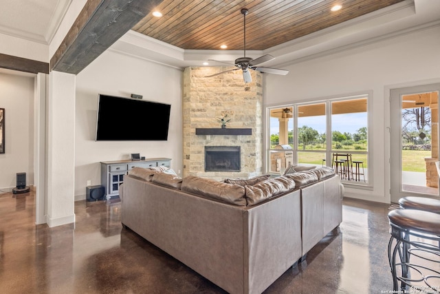 living room with a stone fireplace, ceiling fan, ornamental molding, a towering ceiling, and wood ceiling