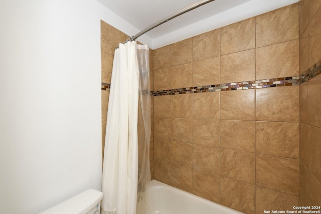 bathroom with shower / bath combo with shower curtain and toilet