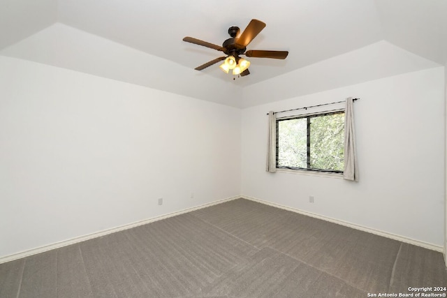 carpeted empty room with ceiling fan and a tray ceiling