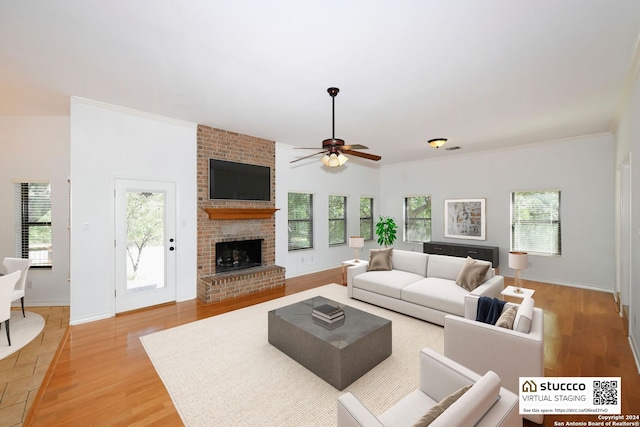 living room featuring a fireplace, light hardwood / wood-style floors, ceiling fan, and a wealth of natural light