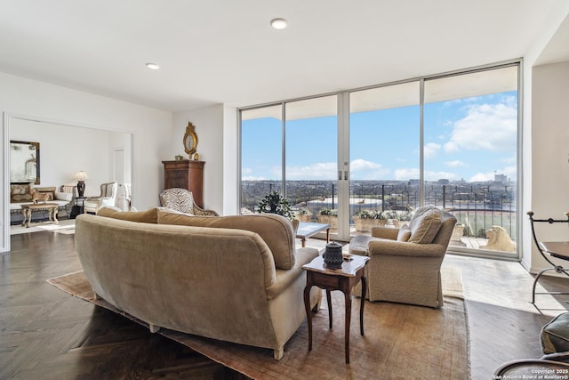 living room with dark parquet flooring and a wall of windows