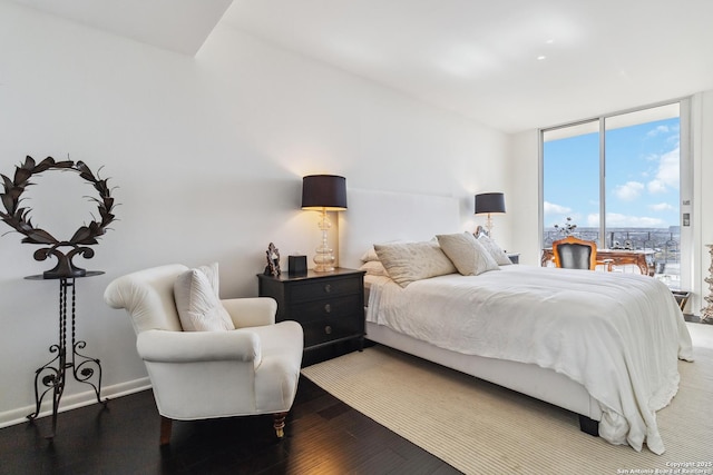 bedroom with hardwood / wood-style floors and expansive windows