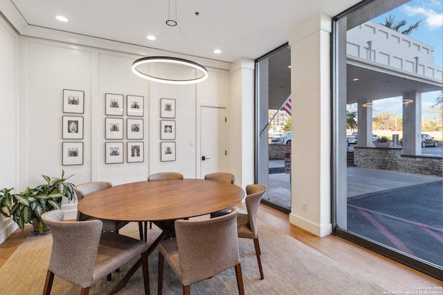 dining area featuring light wood-type flooring and expansive windows