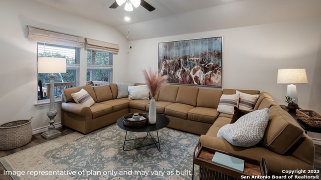 living room with ceiling fan, wood-type flooring, and vaulted ceiling