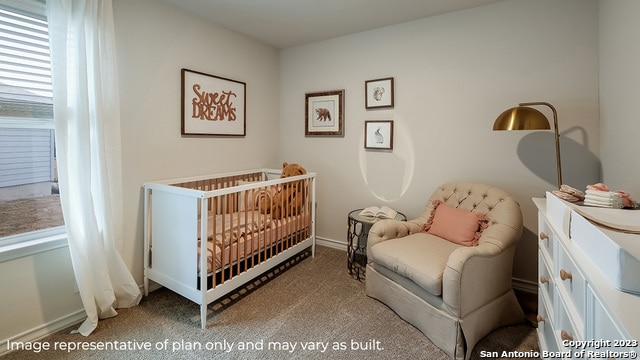 bedroom featuring carpet and a crib