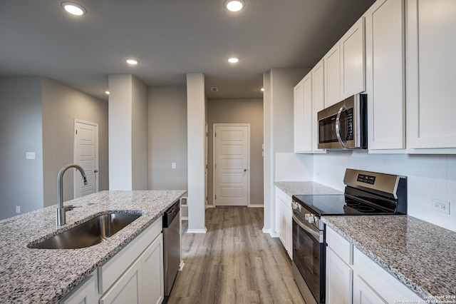 kitchen with white cabinets, light stone countertops, sink, and appliances with stainless steel finishes