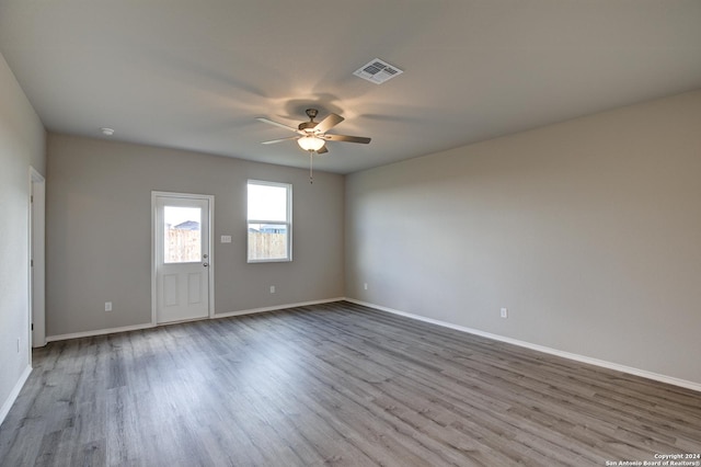 empty room with ceiling fan and light hardwood / wood-style floors