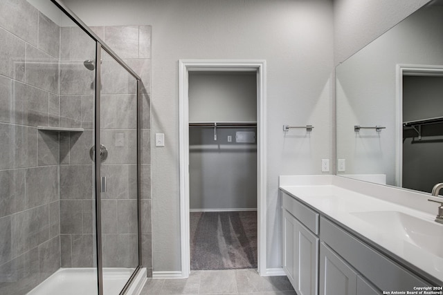 bathroom with tile patterned flooring, vanity, and a shower with door