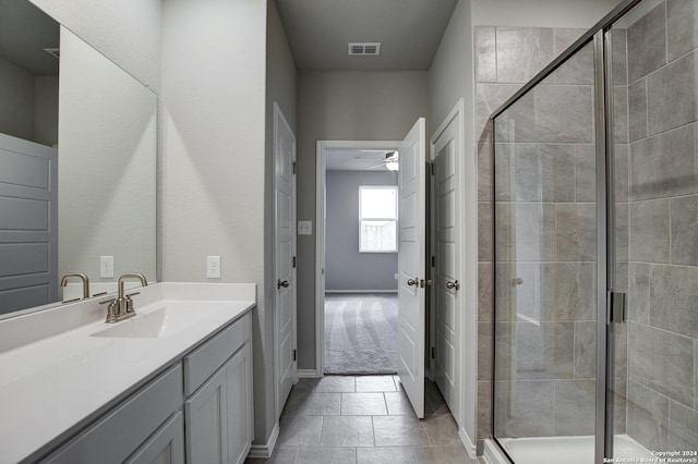 bathroom featuring ceiling fan, vanity, and a shower with shower door