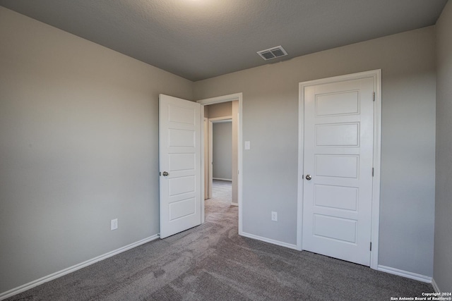 unfurnished bedroom featuring carpet flooring and a textured ceiling