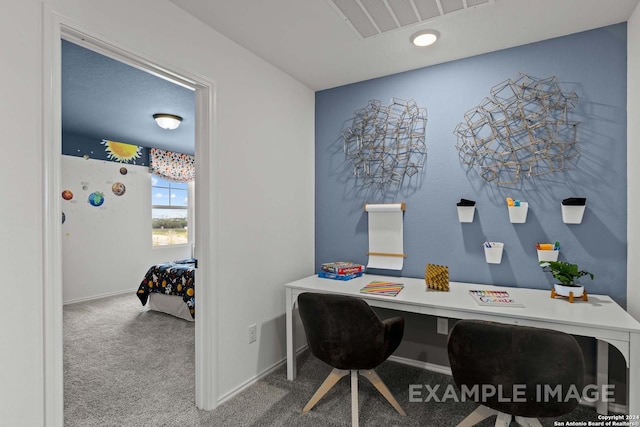 carpeted office featuring a textured ceiling