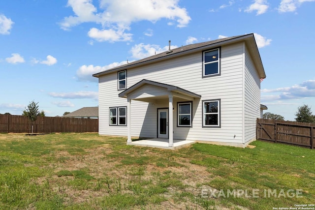 back of property with a yard and a patio