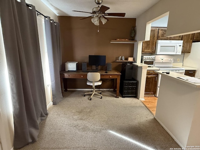 office space featuring ceiling fan, light colored carpet, and a textured ceiling