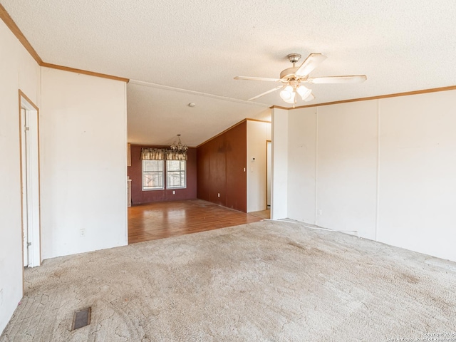 carpeted empty room with ceiling fan with notable chandelier, lofted ceiling, and a textured ceiling