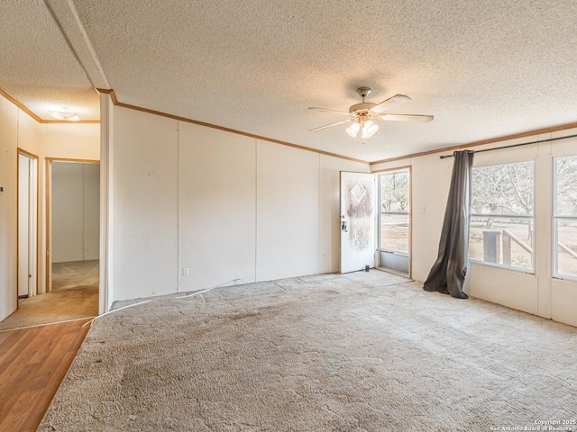 unfurnished room with ceiling fan, light colored carpet, ornamental molding, and a textured ceiling