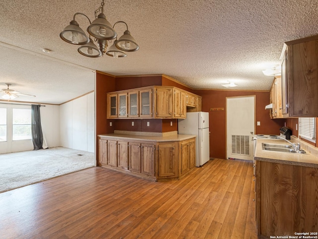 kitchen featuring light wood-type flooring, white fridge, vaulted ceiling, and crown molding