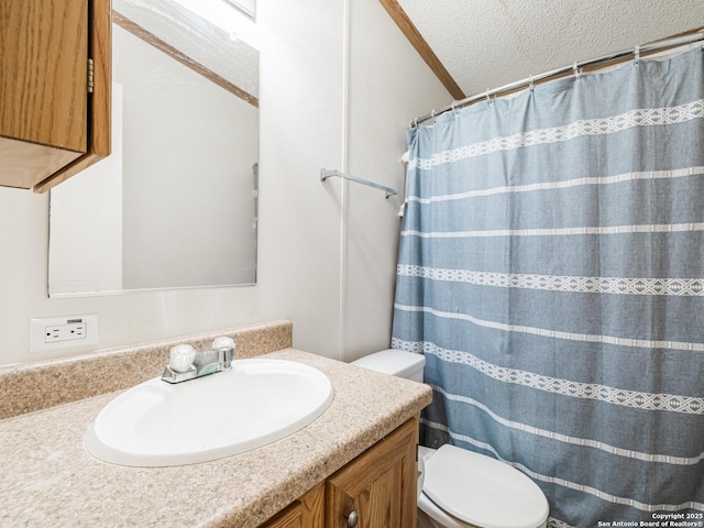 bathroom with vanity, toilet, and a textured ceiling