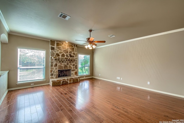 unfurnished living room featuring a fireplace, hardwood / wood-style flooring, ceiling fan, and crown molding