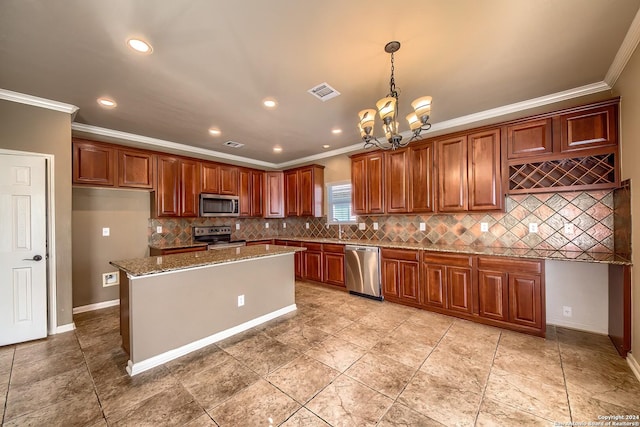 kitchen with light stone counters, a kitchen island, stainless steel appliances, and ornamental molding