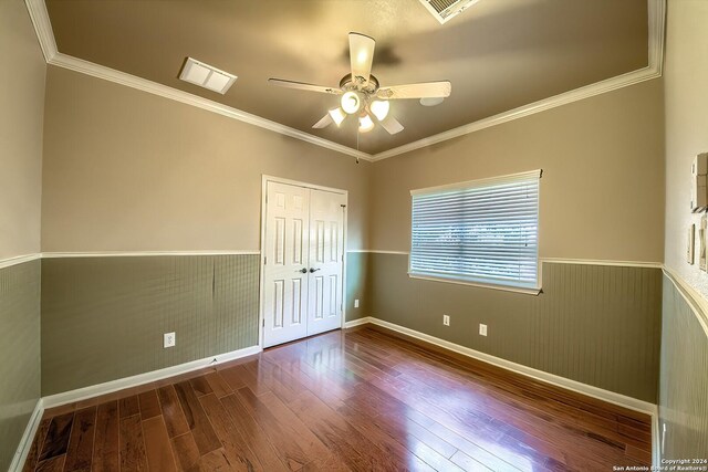 unfurnished room featuring hardwood / wood-style floors, ceiling fan, and crown molding