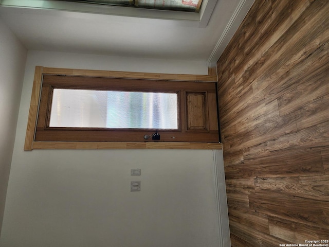 interior details featuring wooden walls and crown molding