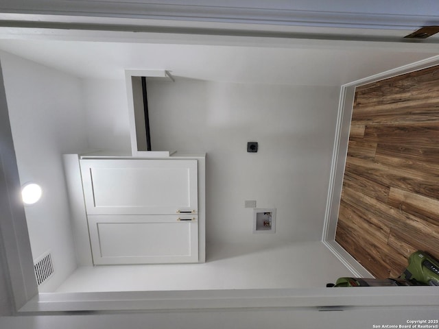 interior space with wood walls, hookup for a washing machine, and hookup for an electric dryer