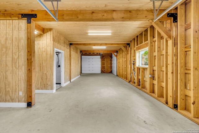 interior space featuring wooden walls and concrete flooring