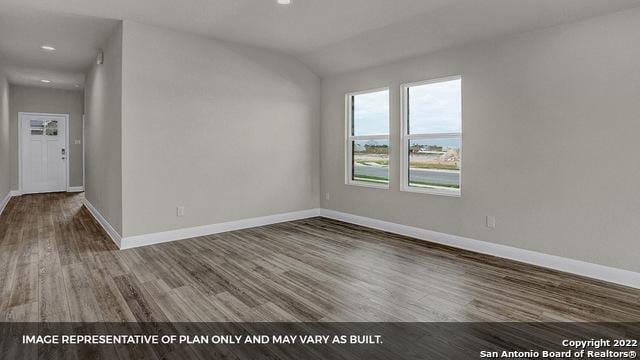 empty room with dark wood-type flooring and vaulted ceiling