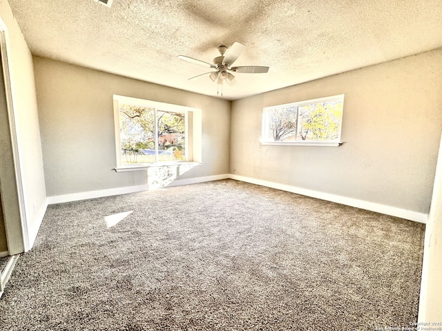 carpeted spare room featuring a textured ceiling and ceiling fan