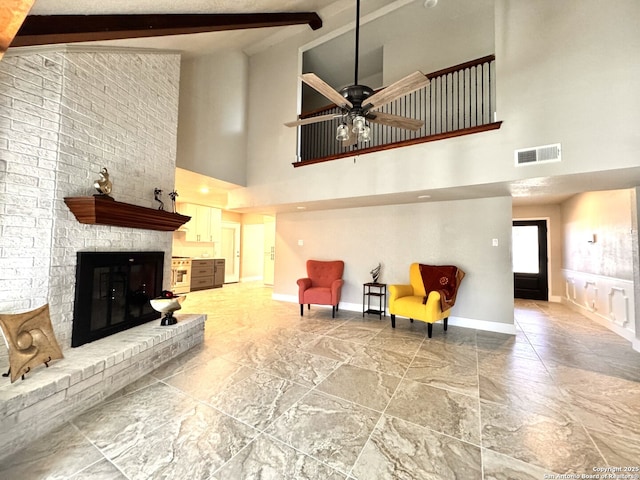 living room with ceiling fan, beam ceiling, a fireplace, and high vaulted ceiling