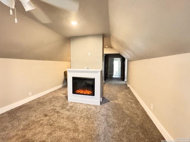 additional living space with carpet flooring, ceiling fan, lofted ceiling, and a textured ceiling