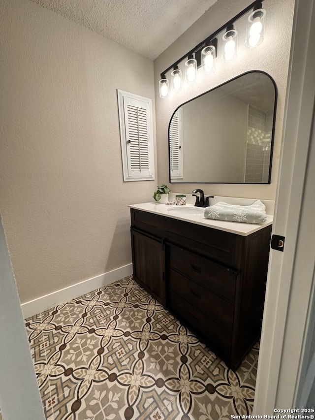 bathroom featuring tile patterned floors, vanity, and a textured ceiling