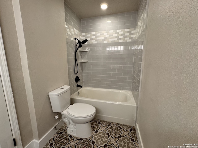 bathroom featuring tile patterned flooring, tiled shower / bath combo, and toilet