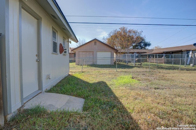 view of yard with a garage and an outbuilding