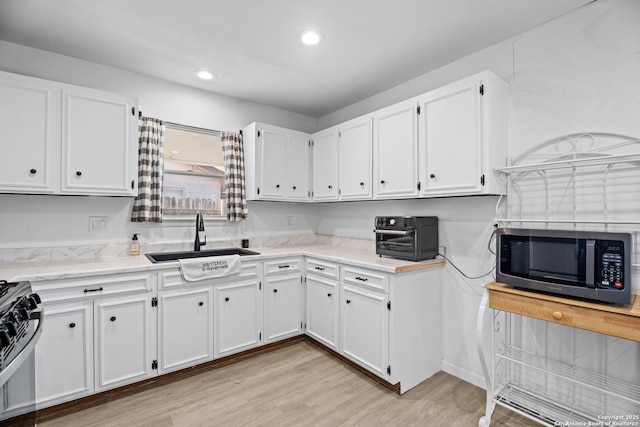 kitchen featuring white cabinets, stainless steel appliances, and sink