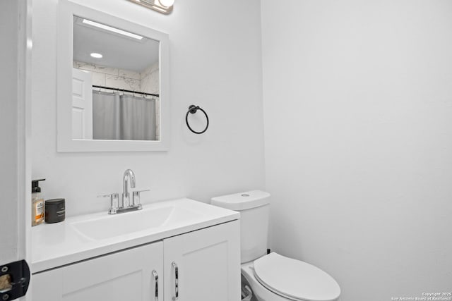 bathroom featuring a shower with shower curtain, vanity, and toilet