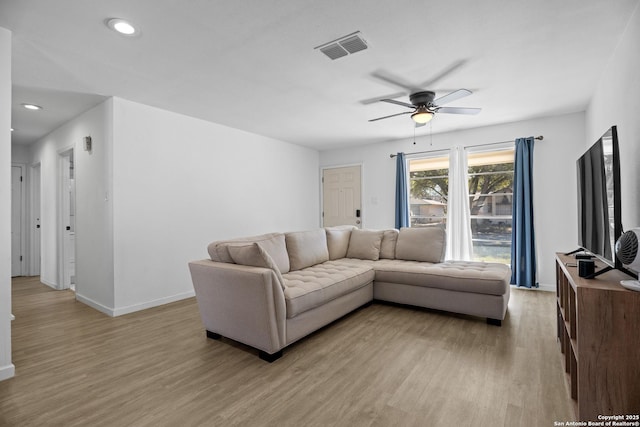 living room featuring ceiling fan and light hardwood / wood-style flooring