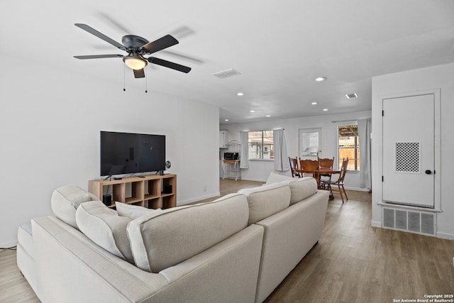 living room featuring ceiling fan and light hardwood / wood-style flooring