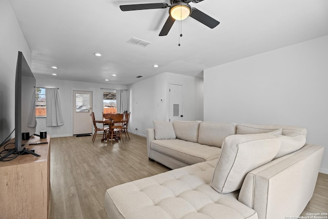 living room featuring ceiling fan and light hardwood / wood-style floors