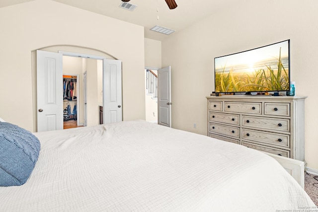 bedroom featuring ceiling fan, a closet, a spacious closet, and vaulted ceiling