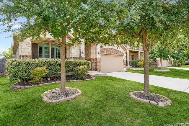 view of property hidden behind natural elements with a garage and a front yard